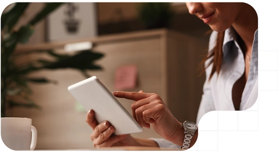 Young woman holding a tablet while signing digitally.