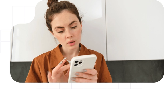 A young woman carefully reading an official notification she received on her cell phone.