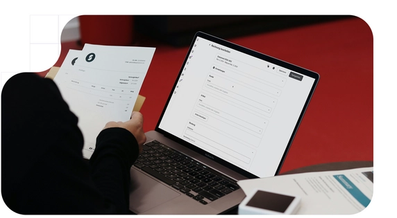 Person checking invoices for their business, on paper and on their pc