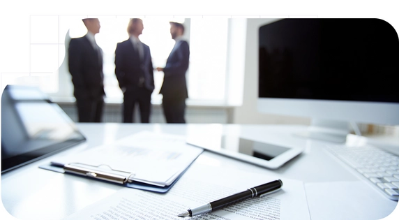 Three men talking near a table with papers about CDD.