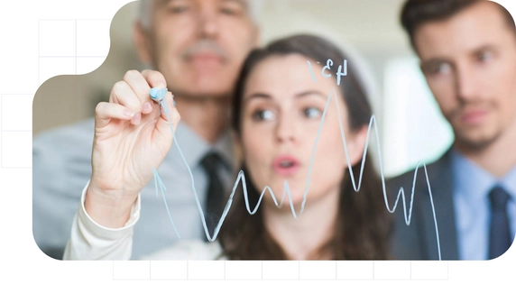 Team of professionals analyzing sales trends on a whiteboard.